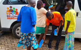 A discharged person recieves sandals as she prepares to board the YBU van