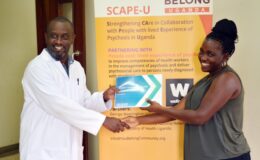 Dr. Mutamba hands over a MHGAP manual to one of the health workers after the training